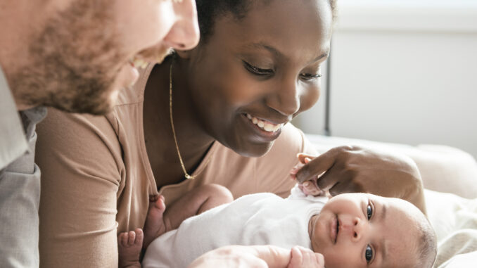A Portrait of a beautiful family, with her nursing baby on bedroom